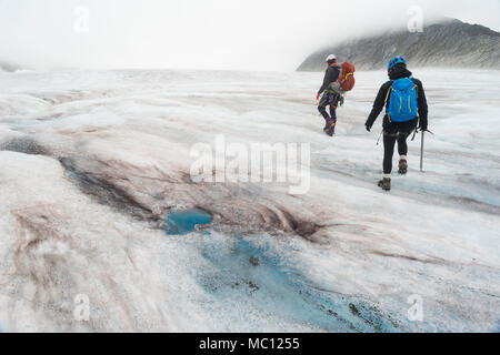 Zwei Personen Wanderung über glitschige Eis auf ein schmelzender Gletscher, Juneau Icefield, Juneau, Alaska, USA Stockfoto