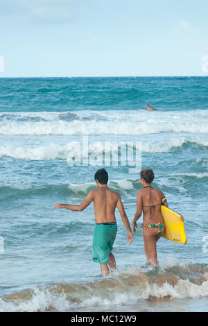 Junge Hispanic Paar ein Ozean mit Surfbrett, Luquillo Beach, Puerto Rico, USA Stockfoto