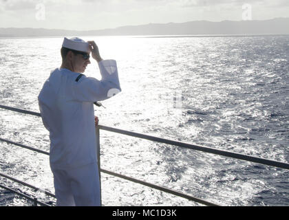 POLARIS, Guam (Jan. 23, 2018) - Rumpf Wartungstechniker 1. Klasse Derek Rody, zugeordnet zu den u-boot Tender USS Frank Kabel (wie 40), passt seine Deckung als bereitet er die schienen, wie das Schiff kehrt nach Hause zurück zu Mann nach 10-Monaten, 31.01.23. Frank Kabel ging Guam März 7, 2017, Unterstützung der maritimen expeditionary Operations in der dritten Flotte Fläche von Operationen und machte einen trockendock Wartung Verfügbarkeit am Vigor Industrial Werft in Portland, Erz Frank Kabel eingeführt, nach Guam, Reparaturen, rearm und reprovisions eingesetzt waren, U.S. Naval Forces in der Indo-Pac Stockfoto