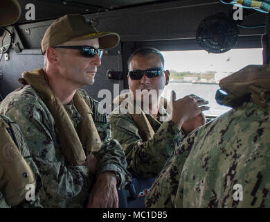 Lt.Cmdr. Paul Duenas, an die in den Küstenzonen Riverine Group (CRG) 1 Ablösung Guam, die technischen Aspekte der MK VI Patrouillenboot beschreibt zu Naval Base Guam befehlshabenden Offizier, Kapitän Hans Sholley Funktionen während einer Kreuzfahrt im Inneren Apra Harbor, Guam, Jan. 18, 2018 zugeordnet. CRG-1 Det Guam ist zum Kommandanten, Task Force (CTF) 75, die primäre Expeditionary task force verantwortlich für die Planung und Ausführung der Küstengebiete Riverine operations, Beseitigung von Explosivstoffen, tauchen Engineering und Bau zugeordnet und Unterwasser Bau in den USA 7 Flotte Bereich der Operationen. (U.S. Marine bekämpfen Kameras Stockfoto