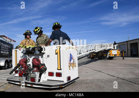 180124-N-TP 832-057 JACKSONVILLE, Fla. (Jan. 24, 2018) der Kongressabgeordnete John Rutherford, Links, Florida's 4th congressional District, und Kapitän David Yoder, Mitte, kommandierender Offizier der Naval Station Mayport, dazu beitragen, einen Brand Leiter während Rutherford besuchen Sie an der Basisstation zu betreiben. Rutherford met Mit Feuerwehrmann und Matrosen zugewiesen, um die Sicherheit zu Base, um ihnen zu danken für ihren Service und Ihre Gedanken auf, wie er diese am besten repräsentieren auf Kongress Fragen voranzutreiben sammeln kann. (U.S. Marine Foto von Mass Communication Specialist 2. Klasse Michael Lopez/Freigegeben) Stockfoto