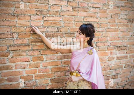 Frauen stehen, die traditionelle Tuch oder Thailand Thai Kleid mit alten Mauern Hintergrund Stockfoto