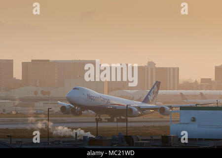 Nippon Cargo Boeing Boeing 747 vom Internationalen Flughafen Los Angeles, LAX, in den frühen Morgenstunden. Die San Gabriel Mountains im Hintergrund. Stockfoto