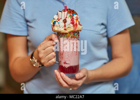 Hans mit Marshmallow Milch shake Cocktail mit Schlagsahne, Cookies, Muffins, behandelt Stockfoto