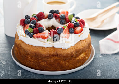 Engel essen Kuchen mit Sahne und Beeren Stockfoto