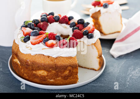 Engel essen Kuchen mit Sahne und Beeren Stockfoto