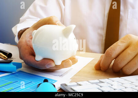 Einsparungen Konzept. Geschäftsmann holding Sparschwein. Stockfoto