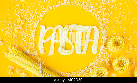 Das Wort "Pasta wird in umfangreichen Briefe von kleinen rohen Makkaroni in einem Kreis unter verschiedenen Arten von Nudeln. Essen auf einem hellen Hintergrund Stockfoto