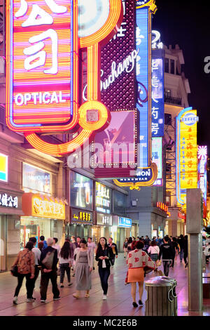 Neonröhren und Käufer auf der Nanjing Road bei Nacht, Shanghai, China Stockfoto