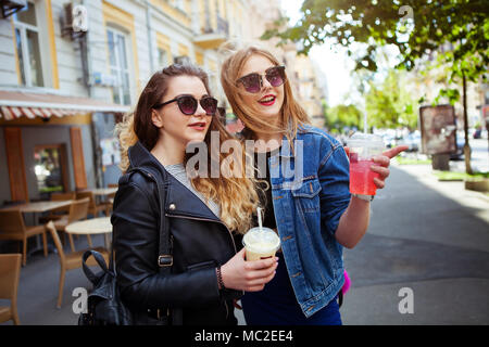 Portrait lustig fröhlichen attraktive junge Frauen mit Getränke Spaß an sonnigen Straße in der Stadt, lächelnd, schöne Momente, beste Freunde Stockfoto