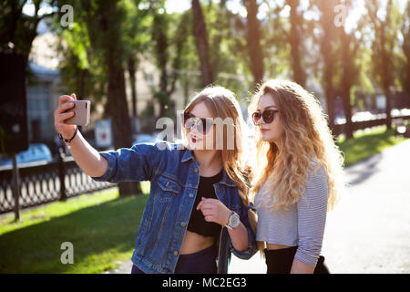 Portrait von niedlichen Ziemlich beste Freunde, Mädchen, umarmen und sich gemeinsam amüsiert, Lächeln, Freude, Schwestern, trendiges Zubehör Zwei schöne junge Frauen selbst machen Stockfoto