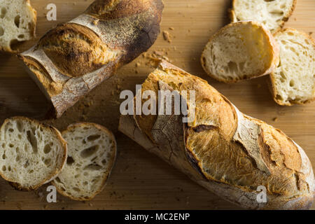 Französisches Brot - Baguette auf einem hölzernen Schneidebrett, Ansicht von oben geschnitten. Stockfoto