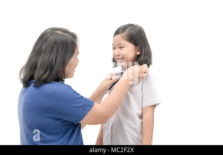 Mutter dressing einheitliche Student ihre Tochter auf weißem Hintergrund, zurück zu Schule Konzept Stockfoto