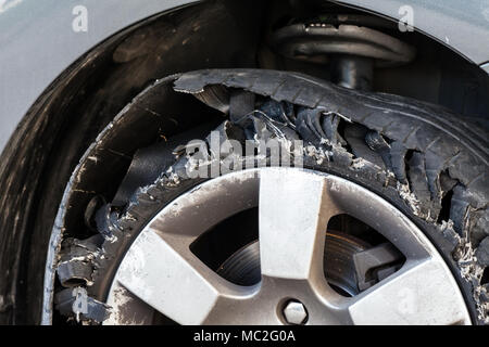 Close up Details einer Ausgeblasen Reifen mit explodierte, geschreddert und beschädigte Gummi auf modernem SUV Automobil. Flache flache Reifen auf einer Leichtmetallfelge, Rip Stockfoto