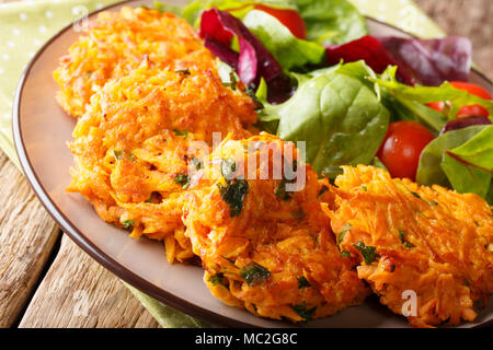 Gesund essen: köstlich süßen Kartoffelpuffer und Frischer gemischter Salat auf dem Teller closeup. Horizontale Stockfoto