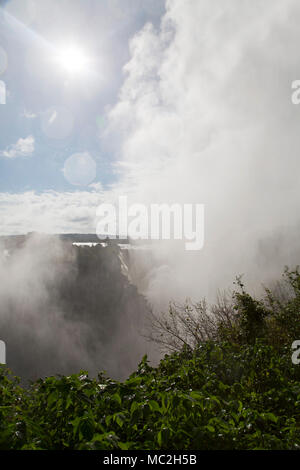 Sonne über der Gischt des Victoria Falls (Mosi-oa-Tunya) an der Grenze zwischen Simbabwe und Sambia. Stockfoto
