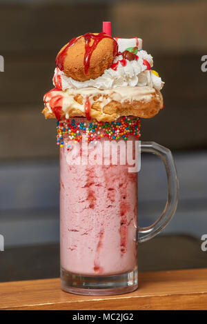 Hans mit Marshmallow Milch shake Cocktail mit Schlagsahne, Cookies, Muffins, behandelt Stockfoto