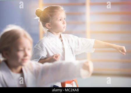 Mädchen in weißen Kimono üben Karate während der extra-curricular Klasse in der Schule Stockfoto