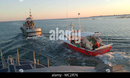 Ein 47-Fuß-Motor Life Boat Crew von der Coast Guard Station Hatteras Inlet schleppt das Fischereifahrzeug Fishunter in Pamlico Sound in der Nähe von Hatteras Inlet, Nord-Carolina, Jan. 26, 2018. Die Fishunter anfing, auf Wasser in Barney Slough und forderten Hilfe über VHF-FM Kanal 16. (U.S. Coast Guard Foto von Seaman Cody Coplin-färbeküvetten/Freigegeben) Stockfoto