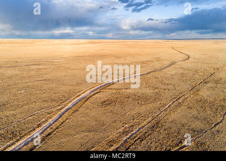 Schmutz der Straße schlängelt sich durch Prairie in Northern Colorado, Frühjahr Luftaufnahme Stockfoto