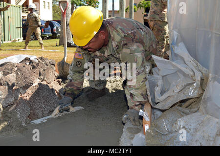 Sgt. Jose Garcia, eine Tischlerei und Mauerwerk Spezialist für die 561St Ingenieur Gesellschaft zugeordnet, 84th Engineer Battalion, 130 Engineer Brigade, 8 Theater Sustainment Command, glatte, Zement bei Schofield Baracke, Hawaii, am Jan. 26, 2018. Garcia ist ein Teil der Konstruktion team Festlegung der Bürgersteig und Grundlage für die 25 Infanterie Division 3. Brigade Combat Team Bronco Memorial in der Nähe platziert werden. (U.S. Armee Foto: Staff Sgt. Armando R. Limon, 3. Brigade Combat Team, 25 Infanterie Division). Stockfoto