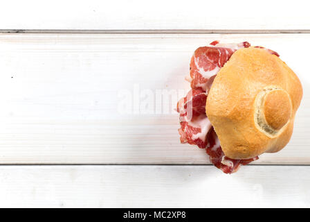 Flach Schuß eines typisch italienischen Einbau als Sandwitch mit coppa (in Piacenza, Nord Italien) auf einem weißen Tisch, wobei ein Schwerpunkt auf der rechten Seite Stockfoto