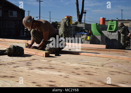 180124-N-PO 132-015 PORT HUENEME, Calif (Jan. 24,2018) Builder 3. Klasse Jorowen Vinluan, zugeordnet zu den Naval Mobile Konstruktion Bataillon Fünf (NMCB 5), ist die Messung ein Stück Holz, um die präzisen Schnitt für die Ausarbeitung einer Außenwand zu erhalten. NMCB 5 ist die Durchführung von Schulungen zu helfen, die Sicherheit, die richtige Technik Verwendung, gewährleisten und neue Seabees mit der Ausrüstung vertraut machen in der Vorbereitung für eine bevorstehende Bereitstellung. (U.S. Marine Foto von Informationssystemen Techniker Seeleute Lehrling Deanna Velasquez/freigegeben) Stockfoto