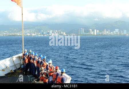 Besatzungsmitglieder an Bord der U.S. Coast Guard Cutter Sherman (WHEC720), eine 378-Fuß hohen Ausdauer Cutter in Honolulu homeported, sammeln auf dem Bug der Vorbereitung in Honolulu Harbor, Jan. 23, 2018 zu kommen. Diese homecoming war das letzte Mal Sherman von der Bereitstellung zurück, als die Crew bereitet sich das Schiff im März außer Betrieb zu nehmen, nach fast 50 Jahren verdienstvollen Service. (U.S. Coast Guard Foto von Petty Officer 2. Klasse Tara Molle/Freigegeben) Stockfoto