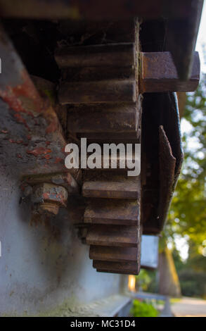 Alten rostigen Zahnrad. Im Hintergrund sind Bäume. Stockfoto