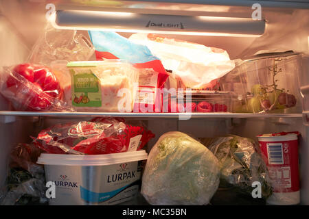 Familie Kühlschrank mit Kunststoff verpackte Obst, Gemüse und Lebensmittel in Großbritannien gefüllt Stockfoto