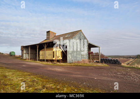 Eine alte lange verlassenen Portamatic Korn-Trockner in einem alten Wellblech verkleideten Scheune auf einem Bauernhof in der Nähe von Dubton, Angus in Schottland gespeichert. Stockfoto