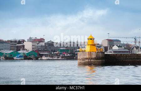 Gelbe Lighthouse Tower auf konkrete Wellenbrecher, Eintritt in Reykjavik port Stockfoto