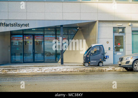 Bodo, Norwegen - 09 April, 2018: Im freien Blick auf die unbekannte Frau, die ihre kleinen minicrosser Auto über den Bürgersteig während des Winters in Bodo Stadt, in Norwegen Stockfoto