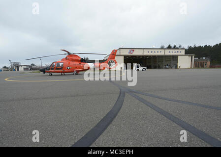 Einem MH-65 Dolphin Helikopter ist auf der Rollbahn am Coast Guard Air Station Humboldt Bay in McKinleyville, Calif gezeigt, folgende Klippe rescue Training, 7. März 2018. Coast Guard Besatzungen routinemäßig Cliff rescue Training Qualifikationen zu erhalten und Kenntnisse in ihren Rettungstechniken im Falle einer Person in Not auf einer Klippe zu erhalten. Stockfoto