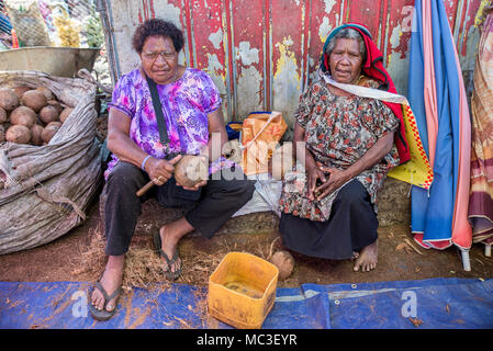 Zwei Frauen Kokosnüsse an der Lebensmittelmarkt von Goroka, Eastern Highlands Provinz, Papua Neu Guinea Stockfoto