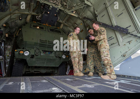 Air Force Piloten, Kapitän Justin Burrier (links) und Kapitän Jakob Wiseman (rechts), 9 Special Operations Squadron, diskutieren Flugpläne mit Marine Corps Gunnery Sgt. Paul Hendee (Center), Artillerie Operations Chief mit Kilo. Akku, 2. Bataillon, 14 Marine Regiment, am Fort Campbell, Ky., 29. März 2018. Marines von Kilo Batterie verwendet eine Luftwaffe MC-130 auf Dugway Proving Ground in Utah zu einem Live-fire raid-Verhalten, das Fliegen von Fort Campbell, auf Dugway. Dort entladen und feuerte vier HIMARS Raketen, die eine einzigartige Fähigkeit, die kommandeure geben mehr Optionen zu behandeln Stockfoto