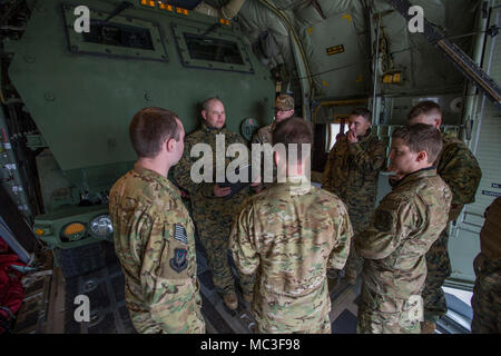 Flieger vom 9 Special Operations Squadron und Marines von Kilo. Akku, 2. Bataillon, 14 Marine Regiment, diskutieren Flugpläne am Fort Campbell, Ky., 29. März 2018. Marines von Kilo Batterie verwendet eine Luftwaffe MC-130 auf Dugway Proving Ground in Utah zu einem Live-fire raid-Verhalten, das Fliegen von Fort Campbell, auf Dugway. Dort entladen und feuerte vier HIMARS Raketen, die eine einzigartige Fähigkeit, die kommandeure mehr Optionen mit Bedrohungen zu begegnen, wenn die anderen Optionen nicht angemessen sind. Stockfoto