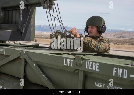 Marine Corps Sgt. Jeffery Hale, ein Launcher Chief mit Kilo. Akku, 2. Bataillon, 14 Marine Regiment, Haken Raketen pods an einem Kettenzug auf ein M142 High Mobility Artillery Rocket System (HIMARS) am Dugway Proving Grounds, Utah, 30. März 2018. Marines von Kilo Batterie flogen von Fort Campbell, Ky., Dugway, wo Sie entladen und feuerte vier HIMARS Raketen, die eine einzigartige Fähigkeit, die kommandeure mehr Optionen mit Bedrohungen zu begegnen, wenn die anderen Optionen nicht angemessen sind. Stockfoto