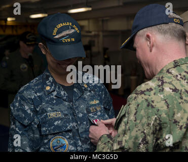 NORFOLK, Virginia (Apr. 3, 2018) --Lt.Cmdr. Katie Cerezo, USS Gerald R. Ford's (CVN 78) Media Department Head, erhält eine Meritorious Service Medal von Kapitän Richard McCormack, Ford's kommandierenden Offizier, während einer feierlichen Preisverleihung in der Schiff-back. Stockfoto