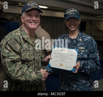 NORFOLK, Virginia (Apr. 3, 2018) --Lt.Cmdr. Katie Cerezo, USS Gerald R. Ford's (CVN 78) Media Department Head, erhält eine Meritorious Service Medal Zertifikat von Kapitän Richard McCormack, Ford's kommandierenden Offizier, während einer feierlichen Preisverleihung in der Schiff-back. Stockfoto