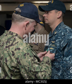 NORFOLK, Virginia (Apr. 3, 2018) --Lt.Cmdr. Michael Collins, USS Gerald R. Ford's (CVN 78) Versorgung der Abteilung zugewiesen, erhält ein Navy und Marine Corps Commendation Medal von Kapitän Richard McCormack, Ford's kommandierenden Offizier, während einer feierlichen Preisverleihung in der Schiff-back. Stockfoto