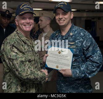 NORFOLK, Virginia (Apr. 3, 2018) --Lt.Cmdr. Michael Collins, USS Gerald R. Ford's (CVN 78) Versorgung der Abteilung zugewiesen, erhält ein Navy und Marine Corps Commendation Medal Zertifikat von Kapitän Richard McCormack, Ford's kommandierenden Offizier, während einer feierlichen Preisverleihung in der Schiff-back. Stockfoto