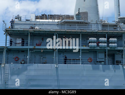 SANTA Rita, Guam (April 04, 2018) Matrosen an Bord der U-Boot Tender USS Emory S. Land (39), Wave goodbye, wie das Schiff Transite Apra Harbor, als sie unterwegs für eine Bereitstellung erhält, April 4. Emory S Land, nach Guam, Reparaturen, rearm bereitgestellt und reprovisions eingesetzten US-Seestreitkräfte im Indo-pazifischen Region. Stockfoto