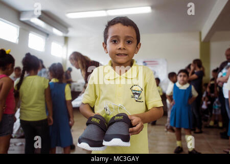 HUMACAO, Puerto Rico, 12. Januar 2018 - ein Junge von Humacao zeigt seine neuen Schuhe. Die FEMA und Gemeindeleitern geholfen, eine Spende organisieren über 150 Paar Schuhe der Kinder auf Hurrikan Maria Überlebenden zu liefern. Stockfoto