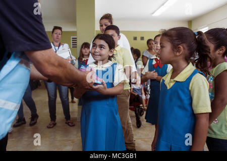 HUMACAO, Puerto Rico, 12. Januar 2018 - Ein junges Mädchen bekommt ein Paar neue Schuhe ab einer Spende von FEMA-Mitarbeiter und der Gemeinde organisiert. Über 150 Paar Schuhe der Kinder waren zum Hurrikan Maria Überlebenden auf der Veranstaltung gegeben. Stockfoto