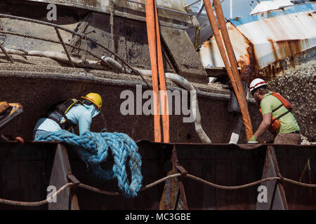 FAJARDO, Puerto Rico, Jan. 30, 2018 - Arbeitnehmer einstellen, Träger eines Schiffes zu heben und aus dem Schiff zu entfernen. Der Umweltschutz Agency (EPA), das in Zusammenarbeit mit dem U.S. Coast Guard (USCG) und FEMA, hat die Mission, die die Identifizierung und die ordnungsgemäße Entsorgung der Schiffe und ihrer gefährlichen Abfällen und Elektronik. Bisher haben 377 Schiffe wurden identifiziert, und 242 Schiffe und ihre Abfälle ordnungsgemäß entfernt worden. Stockfoto