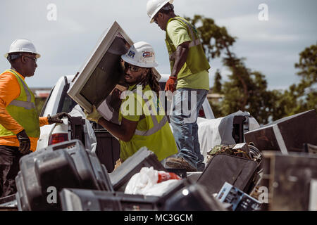 SANTA ISABEL, Puerto Rico, 12. Februar 2018 - Mitglieder der Environmental Protection Agency (EPA) entladen und gefährliche Abfälle kategorisieren ordnungsgemäß an der nächstgelegenen Sammelstelle zu entsorgen. In Zusammenarbeit mit der FEMA, das EPA hat die Aufgabe der Sammlung und ordnungsgemäße Entsorgung Haushalt gefährliche Abfälle (HHW) und Elektronik während der Hurrikan Maria Antwort in Puerto Rico. Stockfoto