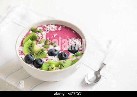 Smoothie Schale mit frischen Beeren, Früchte, Samen und Kokosmilch für gesunde vegane, vegetarische Ernährung Frühstück. Acai blueberry Coconut smoothie Schüssel. Stockfoto