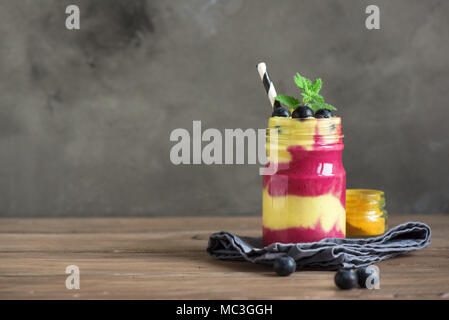 Smoothie Schale mit frischen Beeren, Früchte, Samen und Kokosmilch für gesunde vegane, vegetarische Ernährung Frühstück. Acai blueberry Coconut smoothie Schüssel. Stockfoto