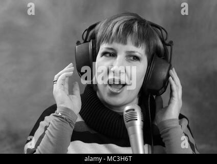 Porträt einer Frau in Kopfhörern singen Musik. Stockfoto